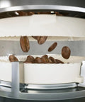 Top Shelf Automatic Espresso Brewer With Sturdy Built In Bean Mill showing freshly roasted coffee beans falling into the grinder.