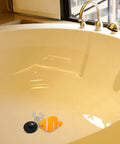 Fish Bathtub Drain Stopper with Chain Rubber for Shower Drains in a bathtub, featuring a black plug and orange fish design.