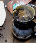 Pouring hot water into Size 4 Cone Coffee Filters, 8-12 Cup, 200 Count, Unbleached Natural Paper, placed in a drip coffee maker.