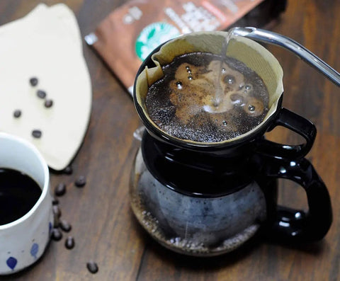 Pouring hot water into Size 4 Cone Coffee Filters, 8-12 Cup, 200 Count, Unbleached Natural Paper, placed in a drip coffee maker.