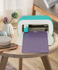 Front view of teal REALIKE Cricut Joy cutting mat device with purple grid mat inserted.