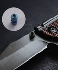 Close-up of knife with 3 Sets Titanium Thumb Studs And Pocket Knife Screws Replacement For Benchmade 535 Bugout, blue and silver knobs visible