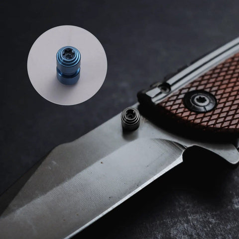 Close-up of knife with 3 Sets Titanium Thumb Studs And Pocket Knife Screws Replacement For Benchmade 535 Bugout, blue and silver knobs visible