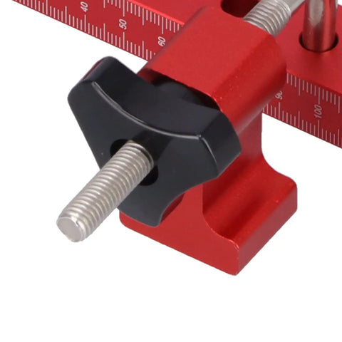Close-up of Dead Nuts On 90 Degree Woodworking Corner Clamping Jig with adjustable screw and metric scale in red aluminum.