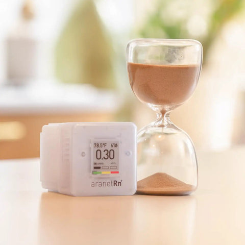 Portable Home Radon Detector With 10 Minute Readings beside hourglass on table