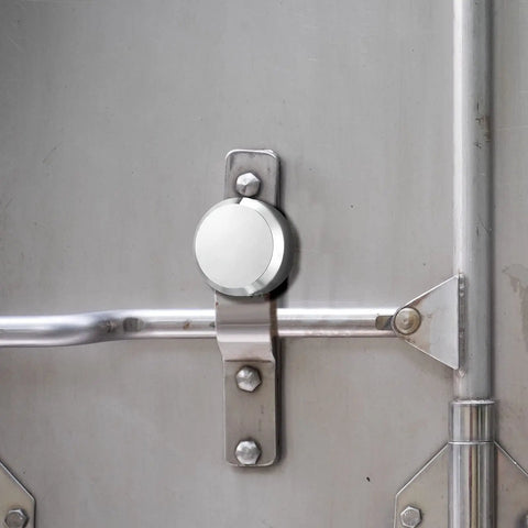 Two Pack Hidden Shackle Puck Padlocks Two And Seven Eighths Inch securing a metal trailer door handle for added security.