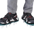 Person wearing Ultimate Lawn Aerator Shoes With Spiked Soles And Secure Hook Straps on grey pants and sneakers