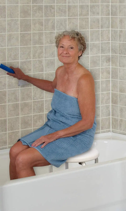 Woman using Compact Shower Stool With Adjustable Height in narrow tub, demonstrating rock solid stability and slip resistant legs.