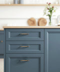 Arch Cabinet Handles in Champagne Bronze on blue kitchen cabinets, 5 inch center to center, European style drawer pulls, zinc alloy hardware.