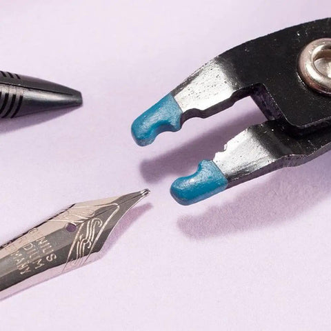 Close-up of Nib Tipping Pliers For Fountain Pens, Replacement Adjustment Tool With Soft Tip Protector next to a fountain pen nib.