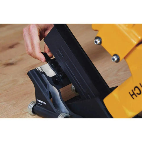 Close-up of Flooring Nailer Rolling Base With Tool Free Thickness Adjustment, showing smooth glide wheels on wood surface.