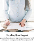 Person using ergonomic anti-fatigue floor mat at standing desk for support and comfort.