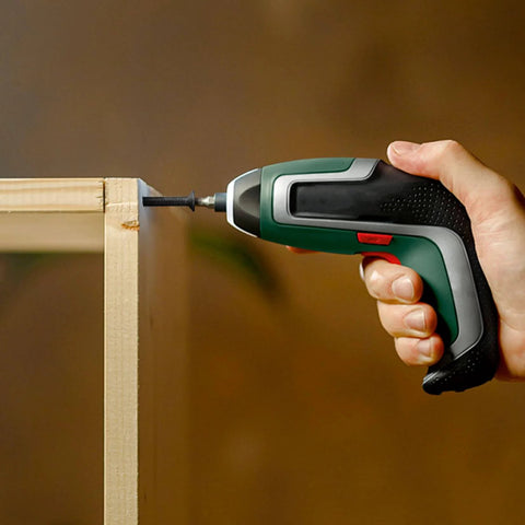 Close-up of a hand using a power drill with the 810 Piece M3 Metric Screw Assortment Kit for assembling wooden furniture.