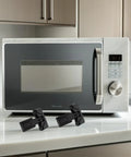 4 Pack Kid Proof Refrigerator Locks with Adhesive No Tool Install ABS Material Modern Black Finish next to a microwave on kitchen counter
