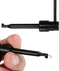 Hand holding Stackable Banana Plug To Test Hook And Alligator Clip Leads Kit For Multimeters, close-up view.