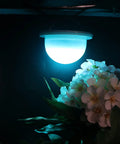 Glowing 4 Pack LED Under Table Light for Parties, RGB color changing uplighting on a floral arrangement, no cables, party ready