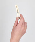 Tough As Nails Wooden Clothespins With Heavy Duty Spring Clip held in hand, showing natural wood finish and rust resistant design.