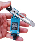 Close-up of Heavy Duty Silver Contact Limit Switch ME8108 with adjustable roller lever, held in hand showing blue casing and metal arm.