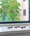 Four Pack Heavy Duty Stainless Steel Double Wheel Sliding Door Roller Assembly on a windowsill with outdoor view.