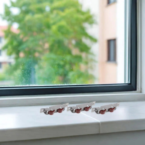 Heavy Duty Stainless Steel Sliding Window Roller Set Featuring Dual Wheels, installed on a window sill for smooth operation.