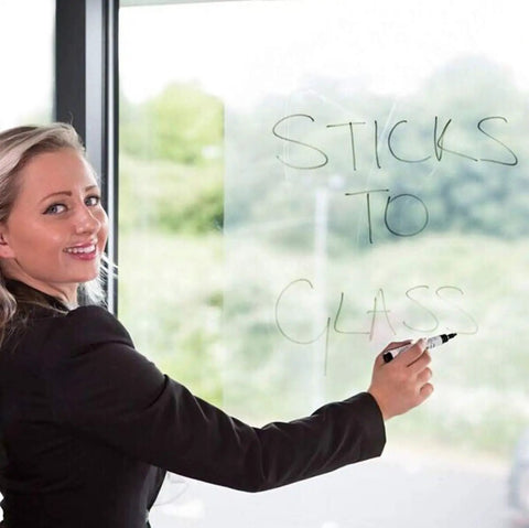 Woman writing on clear contact paper on window, demonstrating Clear Contact Paper 17.7 Inch Wide 118 Inch Long Peel And Stick Self Adhesive Vinyl For Cricut Transfers Transparent Book Covers Removable Wallpaper Roll DIY Friendly Waterproof Surface Protector.