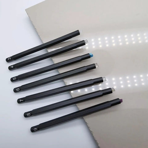 Seven Piece Hardness Test Kit For Rocks And Gems With Portable Scratch Pen Set 3 To 9 Mohs Includes Durable Storage Box For Easy Carry Grab And Go Mineral ID For Industrial Use And Gem Jade Testing. Seven Mohs scratch pens laid out on a flat surface.