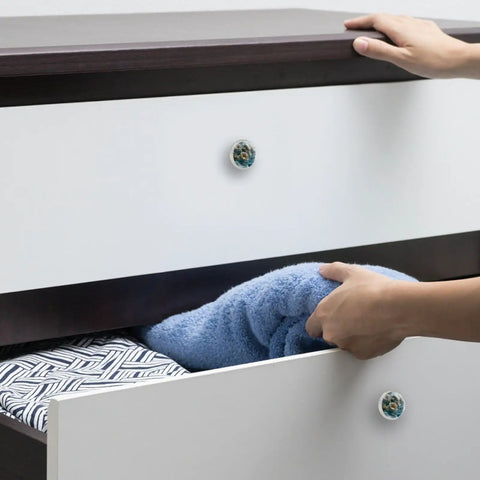 4 Pack Water Floral Cabinet Knobs 1.37 Inch Round White Drawer Pulls on a dresser with hand holding blue towel