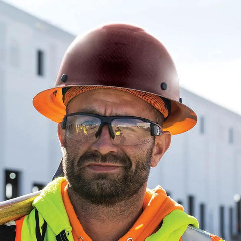 Worker wearing Full Brim KONSTRUCT Series Hard Hat 60452 On The Job Site, Class G Type 1, Brown, with safety glasses