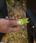 Close-up of hand using latch on 50 Gallon Compost Tumbler In Black No Fuss Easy Spin Barrel For Lawn Clippings And Kitchen Scraps Rotates Effortlessly To Speed Up Composting Moist Well Aerated Materials Turn Into Rich Organic Soil Conditioner And Fertilizer.