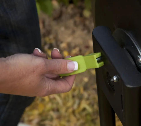 Close-up of hand using latch on 50 Gallon Compost Tumbler In Black No Fuss Easy Spin Barrel For Lawn Clippings And Kitchen Scraps Rotates Effortlessly To Speed Up Composting Moist Well Aerated Materials Turn Into Rich Organic Soil Conditioner And Fertilizer.