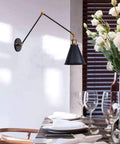 Adjustable Swing Arm Wall Sconce In Matte Metal With E27 Socket Built As A Knockout Go To Nightstand Reading Lamp Featuring A Swivel Pivot Bar, elegant black and gold design in dining setting.