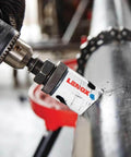 Lenox 2-3/4 in bi-metal speed-slot hole saw mounted on a drill chuck against a metal pipe.