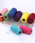Colorful spools of Macrame Cord 1.5mm Cotton String Rope for DIY Crafts 109 Yards With 35 Color Options on a wire rack