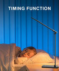 LED Desk Lamp With USB Port For Home Office And Reading, Eye Caring Light With 5 Color Modes And 5 Dimmable Levels, Touch Control And Auto Timer, Piano Style Modern Table Lamp next to a sleeping child at bedtime