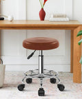 Small brown PU Leather Rolling Stool With Wheels Footrest 360 Degree Swivel Height Adjustable Chair in home setting
