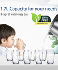 Child drinking water with 1.7L Stainless Steel Electric Tea Kettle With LED Light, BPA Free, Auto Shut Off, in the background