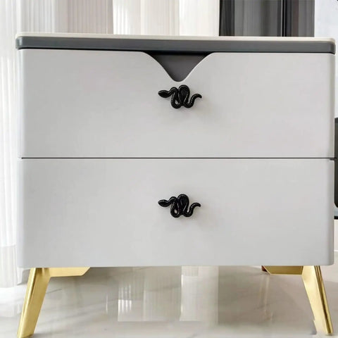 White dresser featuring Snake Shaped Cabinet Knobs Set of 4 Dope Black Zinc Alloy Drawer Pulls for decorative furniture hardware.