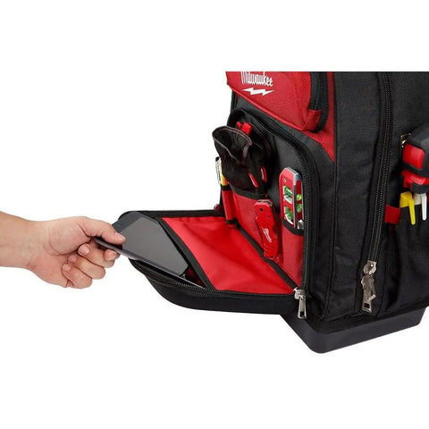 Heavy Duty Canvas Jobsite Backpack With 48 Pockets And Ultra Comfortable Load Bearing Harness Built Like A Tank For Real Deal Contractors And Crew Chiefs Who Want Solid Boss Gear On The Road, showing a hand placing a phone in the front pocket.