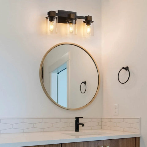 Bathroom with 3 Light Rustic Wood Vanity Light With Clear Glass Shades Modern Black Farmhouse Bathroom Over Mirror Fixture above round mirror.