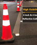 Eight 28 Inch Orange PVC Traffic Cones With Black Base in a row on a road at night, showcasing high visibility with reflective collars.