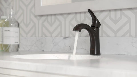 Weller Slick Single Handle Bathroom Sink Faucet With Single Hole Or Three Hole Mount In Tuscan Bronze Finish And Push And Seal Drain Water Efficient Water Sense Certified For Modern Traditional Bathrooms LG42WR0Y shown with water flowing into white sink
