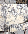 Straight Up Solid Hand Carved Arabescato Marble Wall Mount Sink With Polished Fluted Stone Vanity Basin shown from side angle, detailed view.