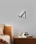Modern Rotatable Cylinder Wall Sconce Wall Mount Reading Spotlight installed above a wooden bedside table in a cozy bedroom.