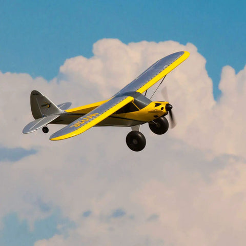 Carbon Cub S 2 1.3m RC Airplane BNF Basic With SAFE Technology for easy flying against a cloudy sky, showing yellow finish.