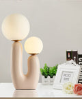 Double-Headed Nordic Modern Table Lamp With Plant Art on white surface, featuring sleek design and round bulbs, plug in with switch.