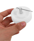 Hand holding a single wheel from Four Pack White Nylon Furniture Casters Wheels For Drawers And File Cabinets No Squeak Glide Heavy Duty