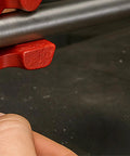 Close-up of the Tiny But Mighty 3 Inch Mini Handheld Vise With 1.25 Inch Jaws holding a metal rod, showcasing adjustable tension.