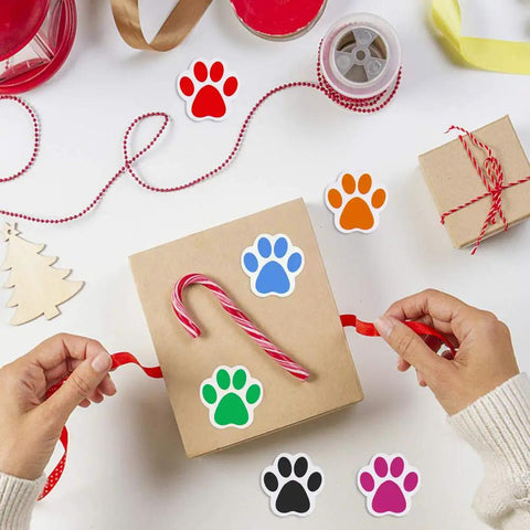 Hands wrapping a gift with Dog Paw Print Stickers Roll 500 Self Adhesive Paw Labels Colorful Animal Shape Wall Decals