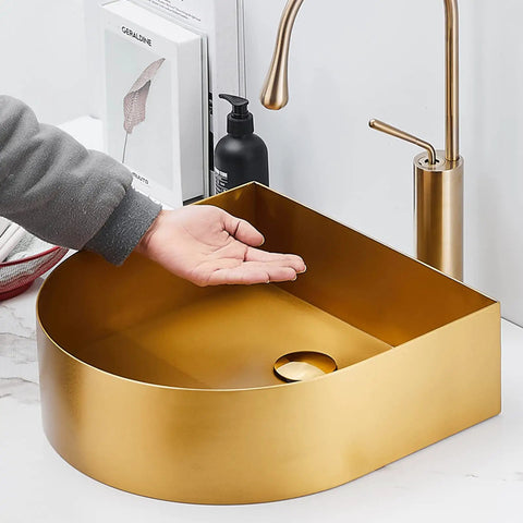 Top Shelf Stainless Steel Gold Vessel Sink, Semi Circular Above Counter Basin With Push Type Drain, showing hand above the sleek gold basin.