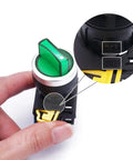 Close-up of a 22mm SPST 1NO two position maintained latching rotary selector switch with green LED indicator held in hand.